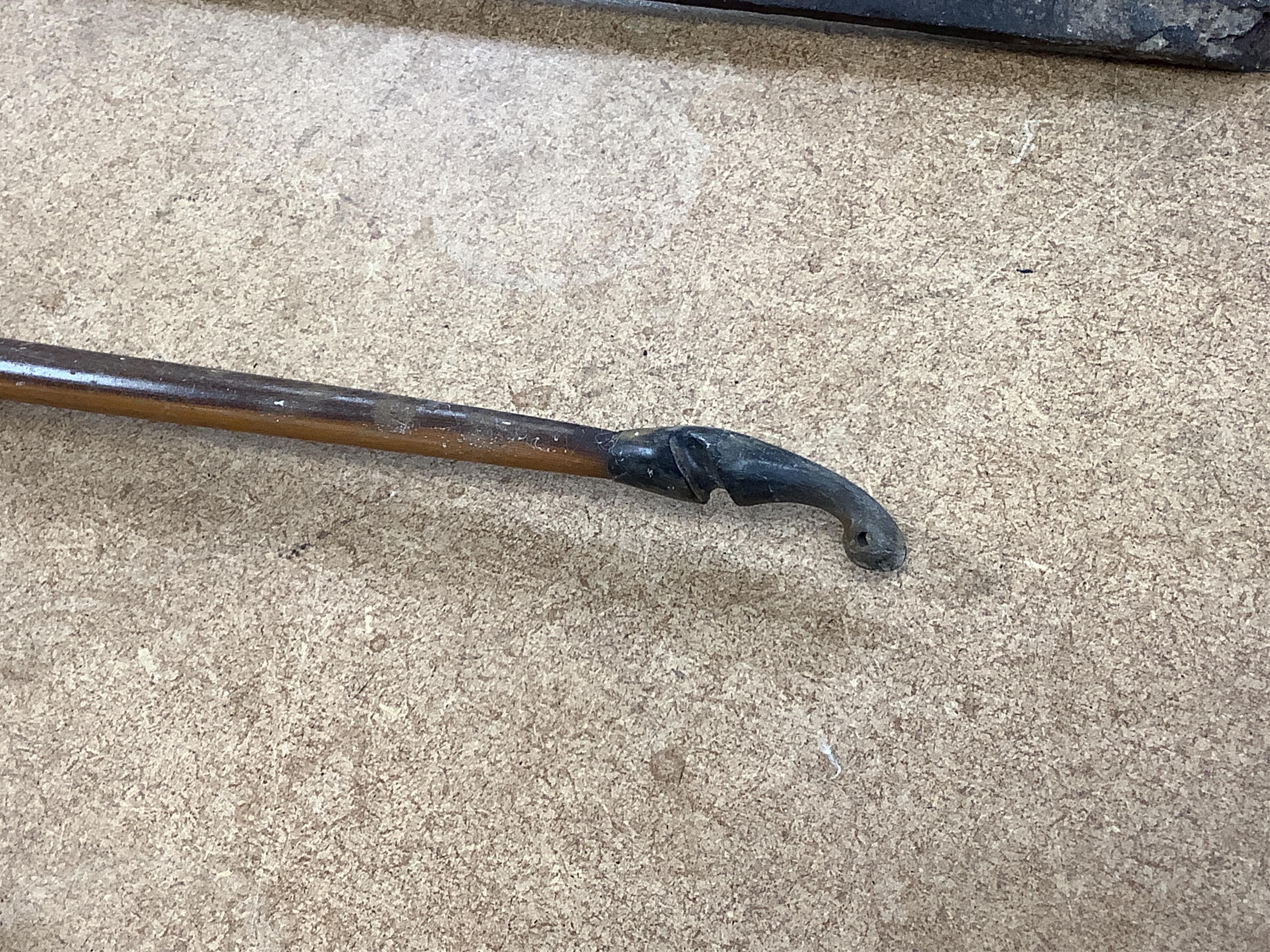 A collection of tribal spears, a fish hook, a cased snooker cue, etc.